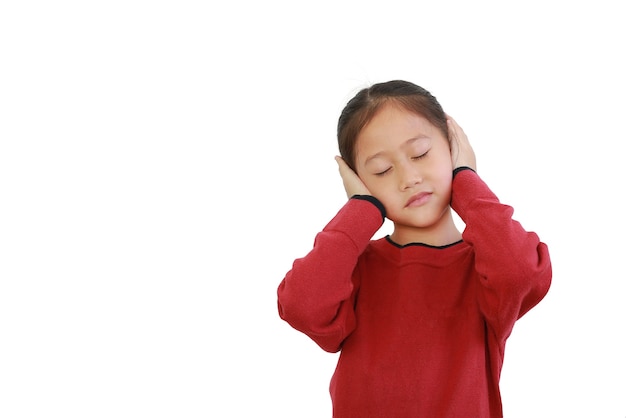 Asian child placing hands on ears and closed eyes on white