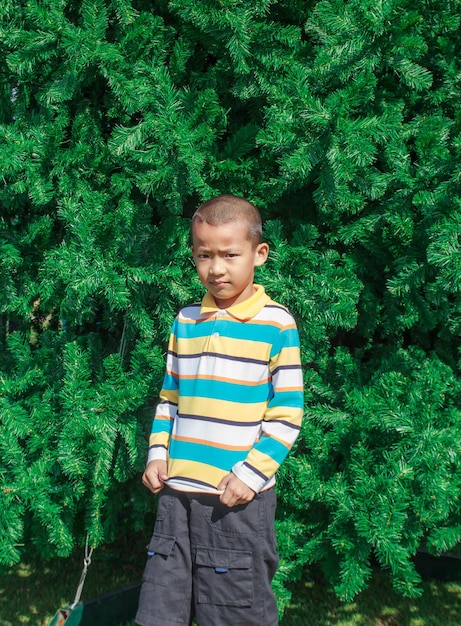 Asian child standing at christmas tree