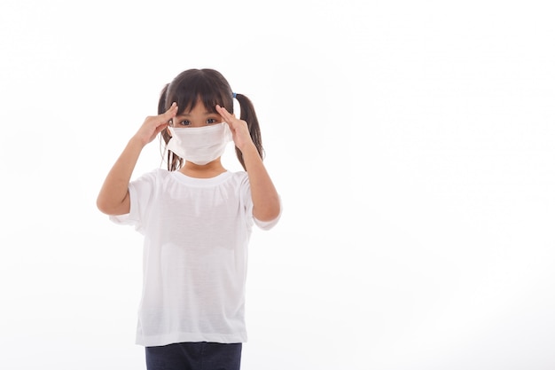 Asian child wearing a medical mask is feeling headache on white