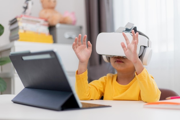 VRゴーグルでデジタル仮想世界を探索するバーチャルリアリティVRキッドを持つアジアの子供
