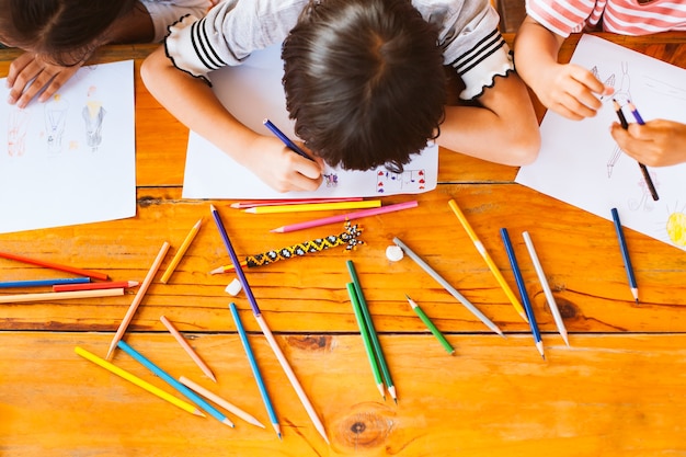 Asian children drawing and painting with crayon together