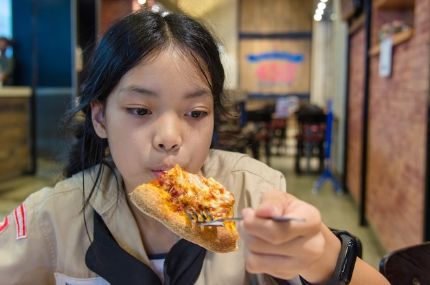 Asian children eat pizza