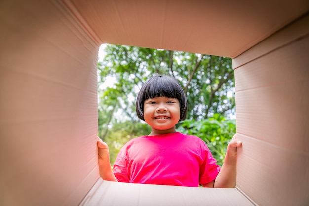 Asian children playing in cardboard boxes