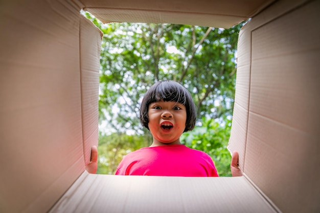 Asian children playing in cardboard boxes