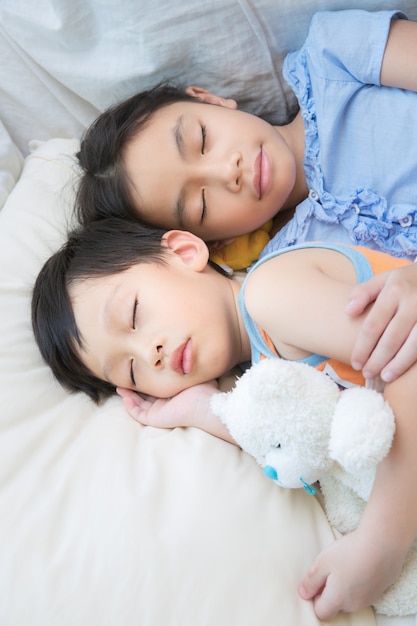 Asian children sleeping with teddy bear