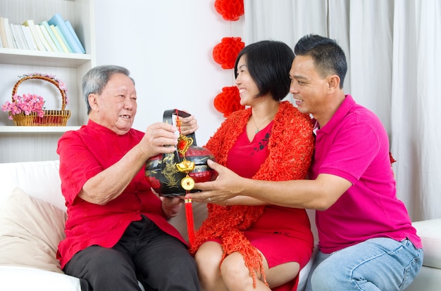 asian childrern presenting gift basket to parent on chinese new year