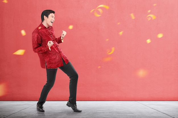 Un uomo cinese asiatico in abito cheongsam celebra il capodanno cinese