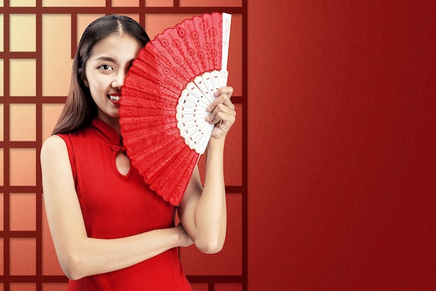 Photo asian chinese woman in a cheongsam dress holding fan celebrates chinese new year. happy chinese new year