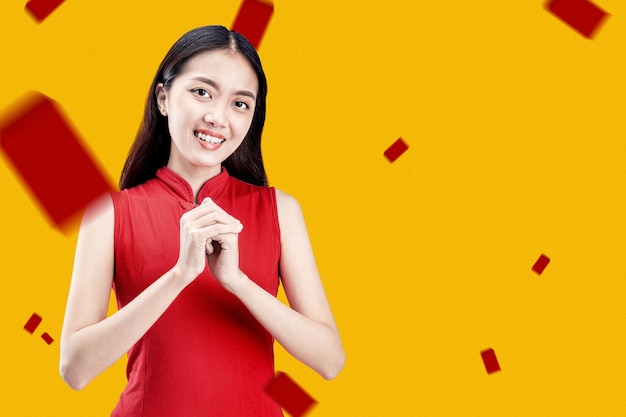 Asian Chinese woman in a cheongsam dress with congratulations gesture. Happy Chinese New Year