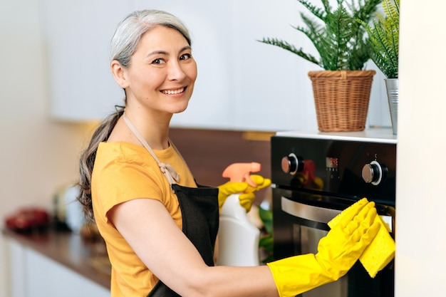 Asian cleaning lady detergents kitchen apron smiling