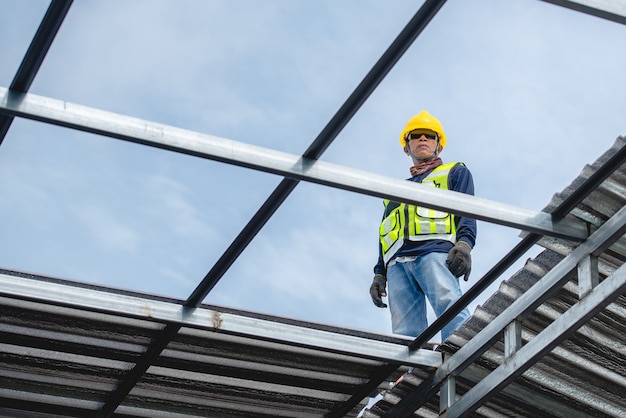 Asian construction workers are on the roof structure of the building in the construction area. Going to install the roof