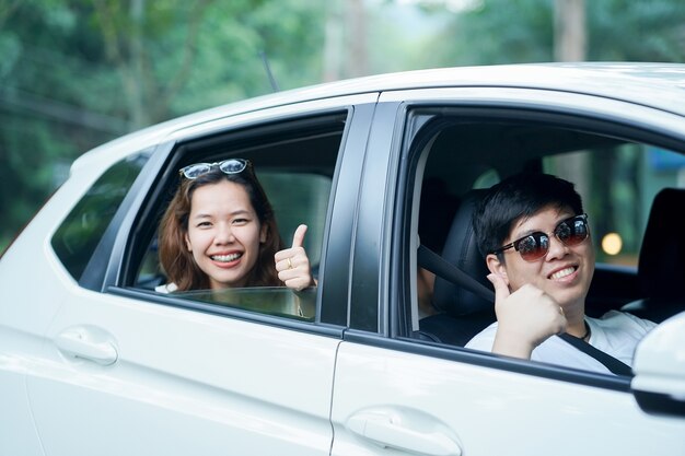 asian couple in the city car show thumb up for guarantee