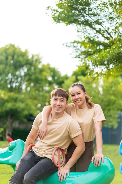 Asian couple love smiling and sitting on rockky horse