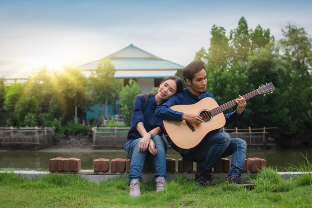 Asian Couple playing guitar rest in summer