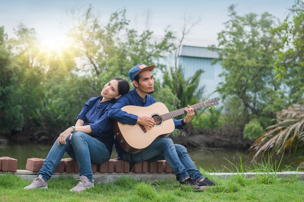 Asian Couple playing guitar rest in summer