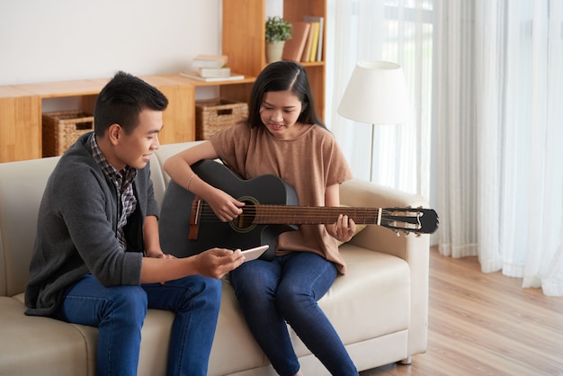 Asian couple playing guitar