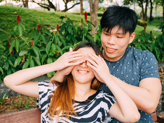 公園でお互いに遊んでいるアジア人のカップル