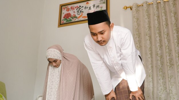 Asian couple praying together at home