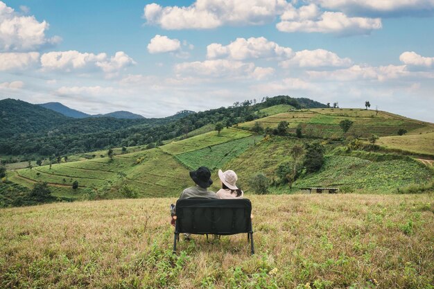 Foto coppie asiatiche che si rilassano sulla montagna nella scena rurale