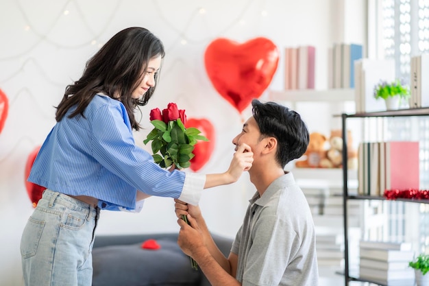사진 아시아 커플 이 꽃 을 선물 하는 사랑 의 놀라움 을 보여 주고 있다