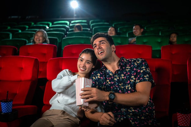 아시안 커플은 사랑스럽고 로맨틱한 극장에서 함께 코미디 영화를 보고 있습니다. 가족을 위한 발렌타인 데이 여행