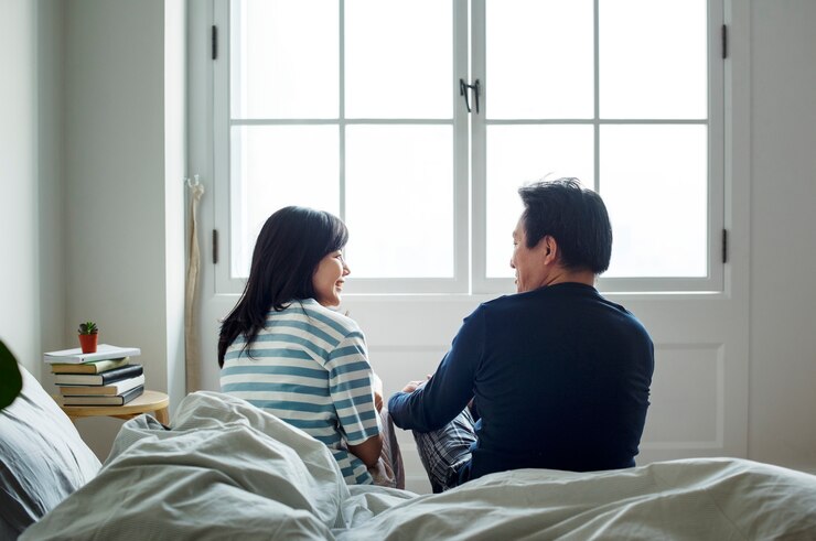 Photo 침대에서 함께 이야기하는 아시아 부부