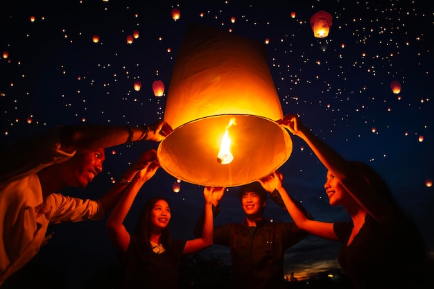 Asian couple traveller setting yi peng lantern in loi krathong festivities celebration in chiang mai