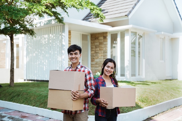 Asian couple with cardboard box in the house