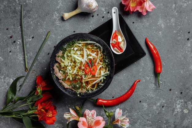 Asian cuisine, Beef soup fo in a black plate on a dark background