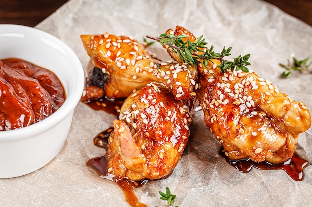 Asian cuisine Glazed fried chicken legs with spicy chili sauce and sesame seeds