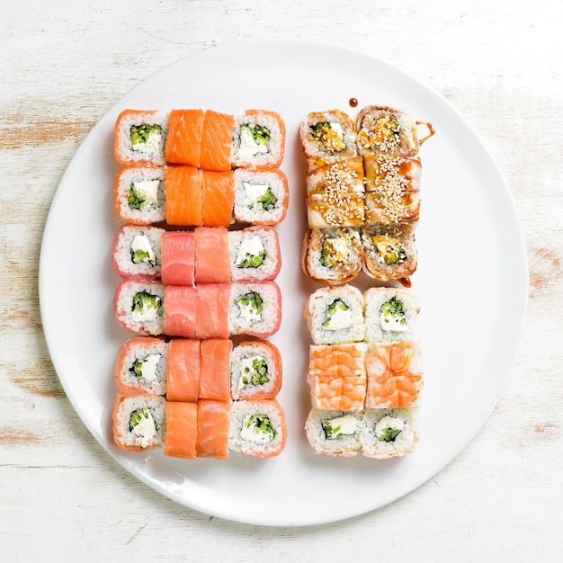 Asian cuisine Large set of sushi rolls on a plate Top view On a white background