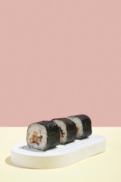 Asian culture Japanese hosomaki sushi rolls with eel on a pink and yellow background Oriental culinary eastern cooking