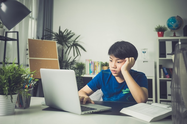 Asian cute boy using laptop computer