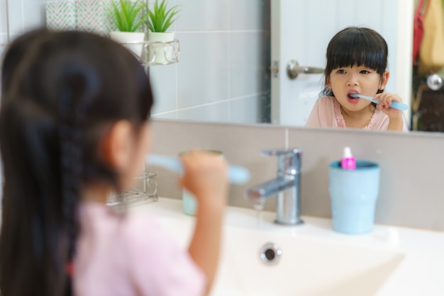 Asian cute child girl or kid Squeeze the toothpaste into toothbrush