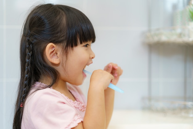 Asian cute child girl or kid Squeeze the toothpaste into toothbrush