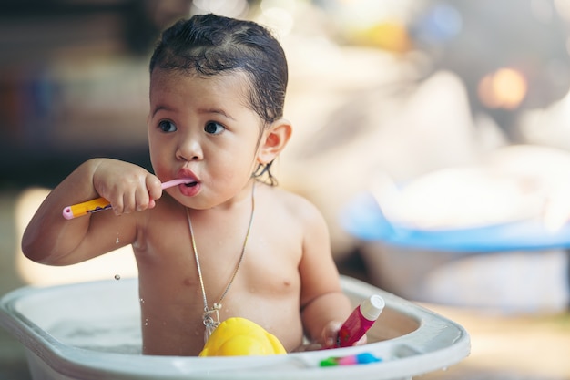 Asian cute kid brushing her teeth by toothbrush