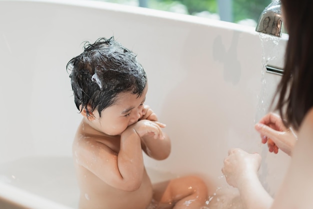 Asian cute kid girl toddler having a bath wash hair cleaning bathing bath tub with her mother Mother love and care happy baby girl innocent have fun playing with water enjoying Baby concept