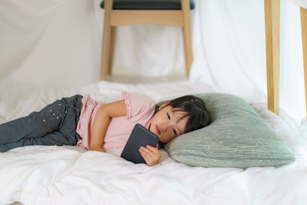 Asian cute little girl watching cartoon in smartphone