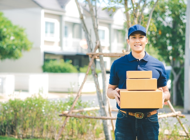 Asian deliver man in blue uniform holding package box