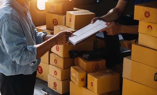 Asian delivery man in cargo van checking boxes