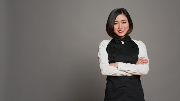 Asian diner employee prepared to serve food at tables