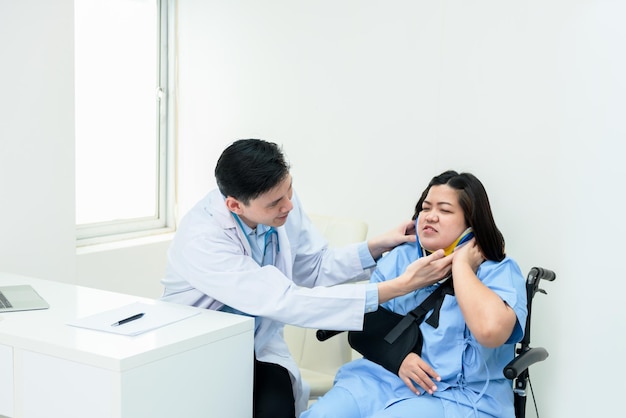 Asian doctor checking the condition of a female patient who has\
a neck injury due to displacement