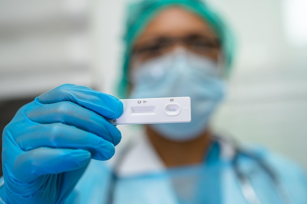 Asian doctor holding Saliva Antigen Test Kit for check Covid19 coronavirus in hospital