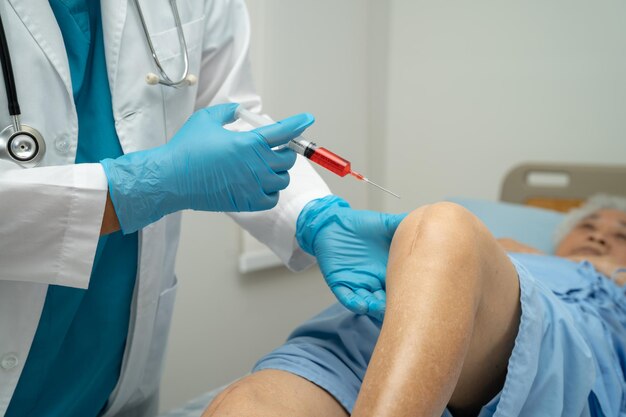 Photo asian doctor inject hyaluronic acid platelet rich plasma into the knee