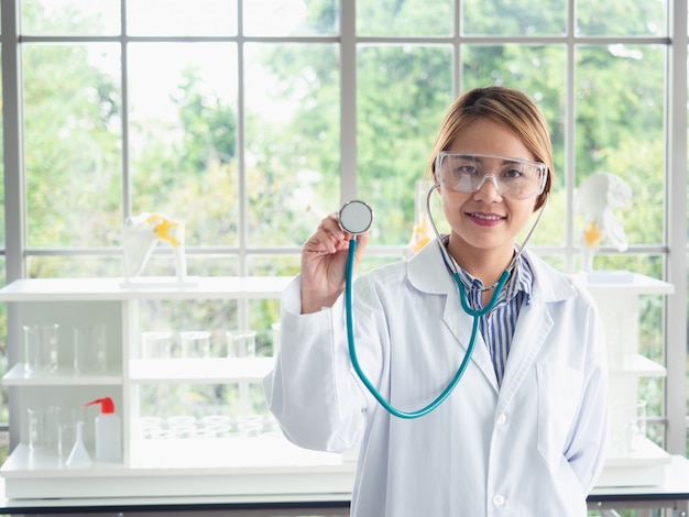 Il medico asiatico sta mostrando lo stetoscopio in laboratorio