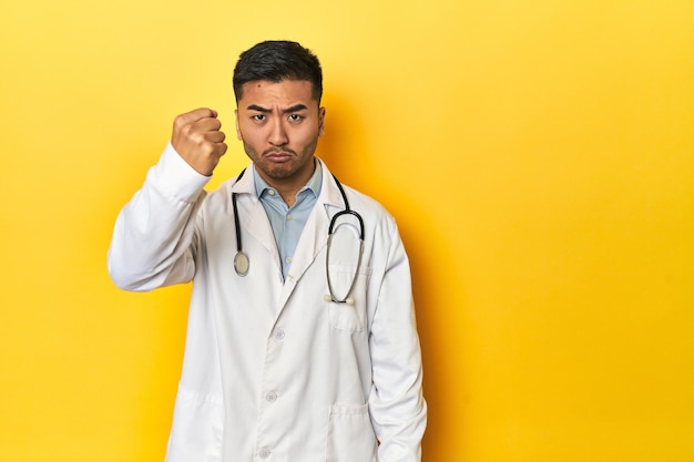 Asian doctor showing fist to camera aggressive facial expression