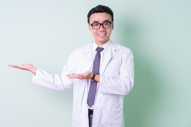 Asian doctor standing on green background