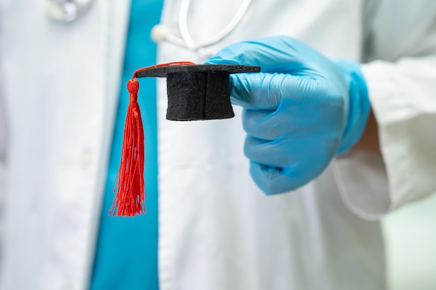 Lo studio medico asiatico impara con il cappello del divario di laurea nel concetto di medicina dell'educazione genio brillante intelligente del reparto ospedaliero