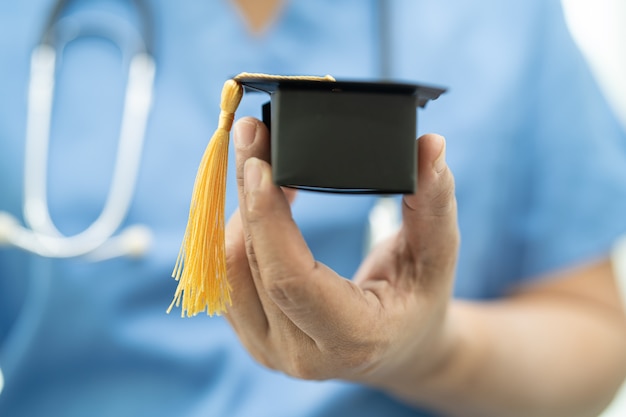 Asian doctor study learn with graduation gap hat in hospital ward