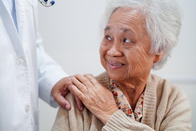 Asian doctor touching patient to support consolation encourage and help support health care medical
